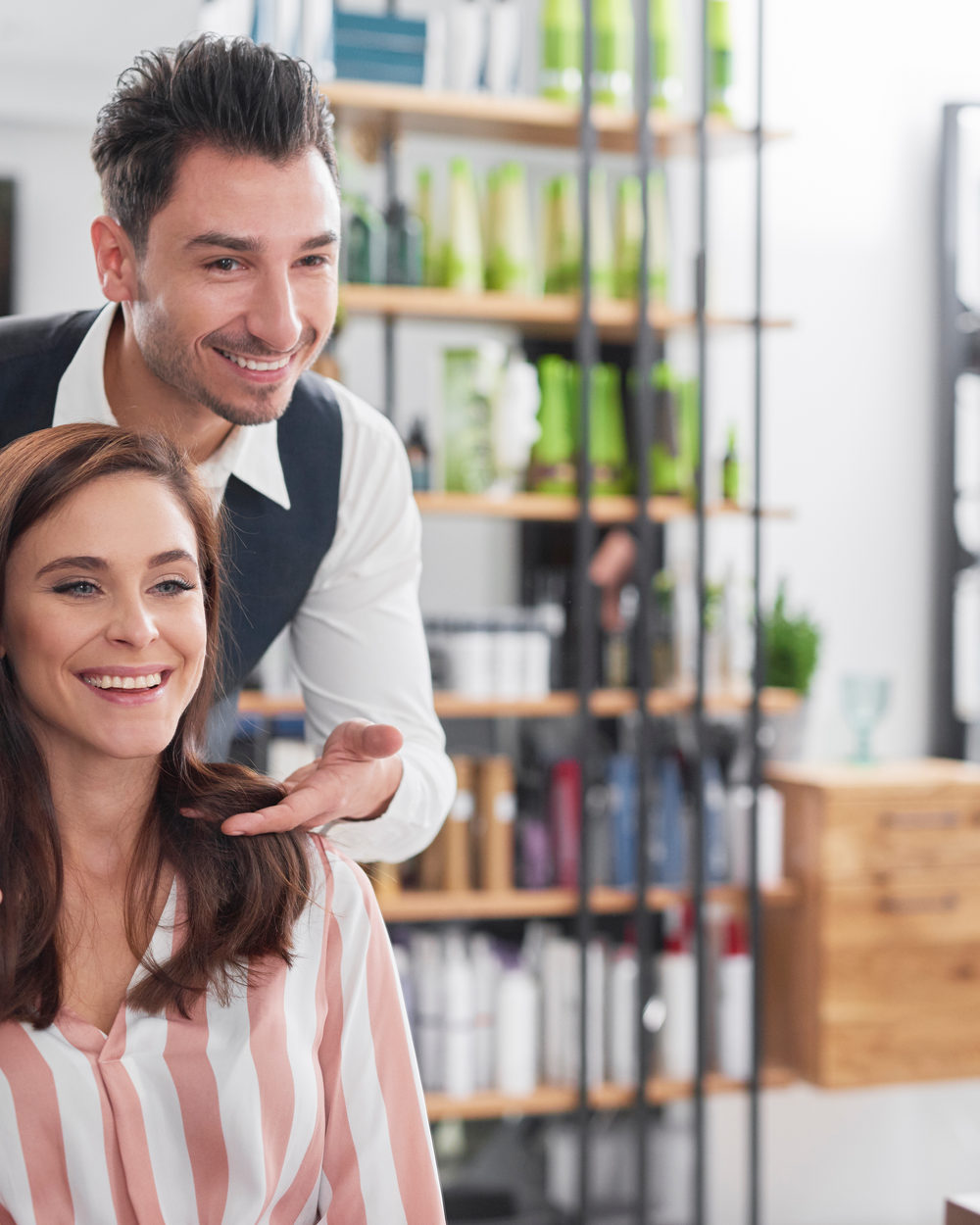 A stylist finishing a client's blowout at the salon